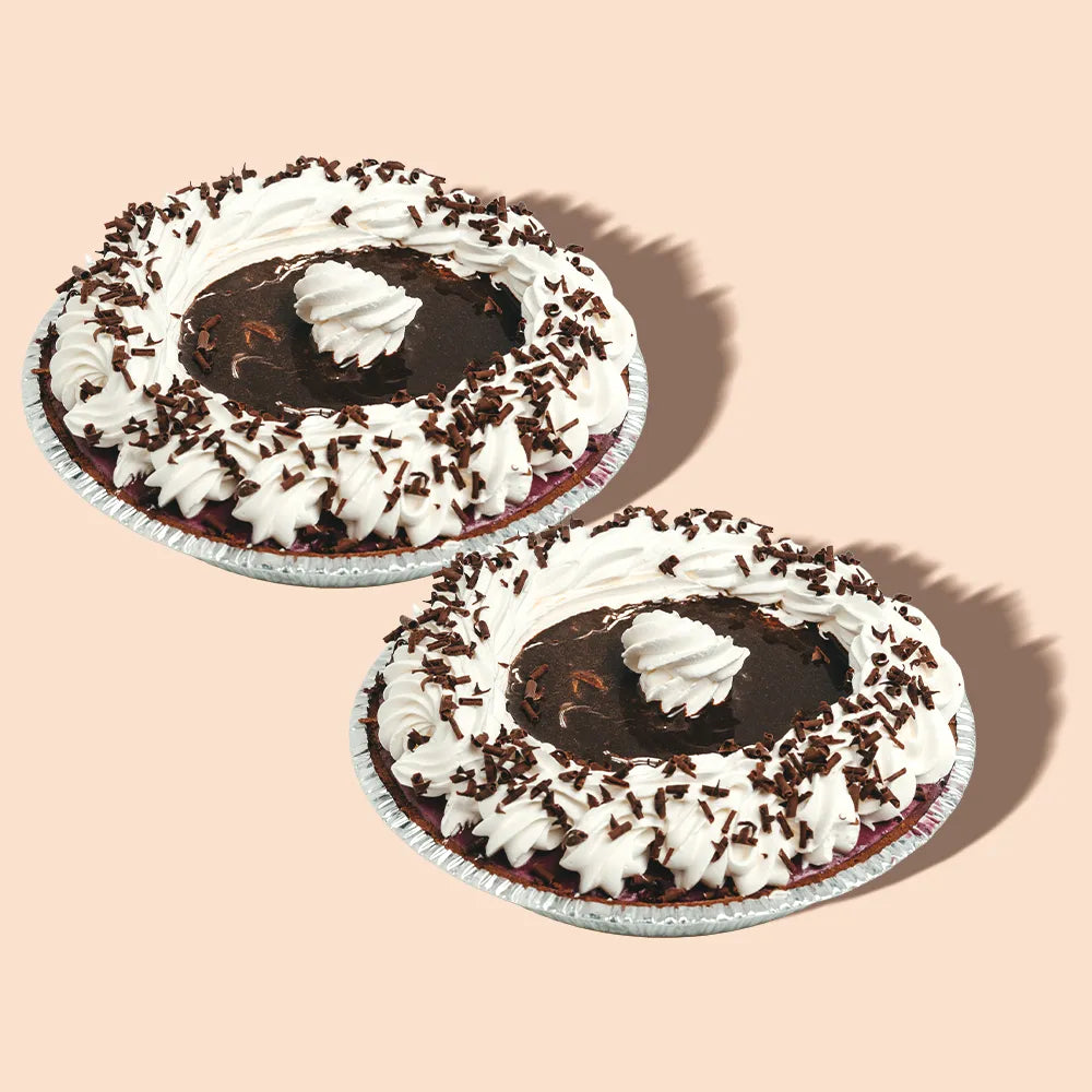 Two black raspberry ice cream pies with whipped cream and chocolate shavings.
