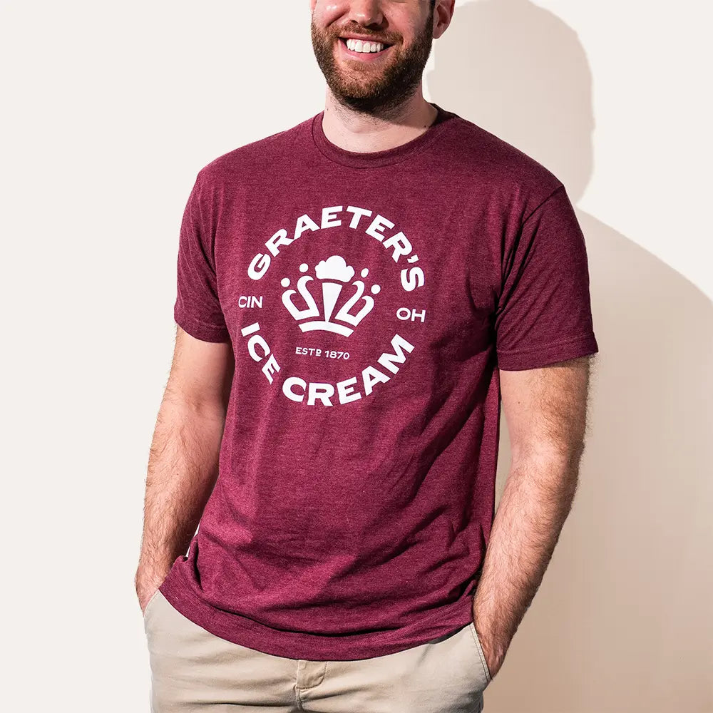 Man wearing a maroon t-shirt with Graeter's Ice Cream logo on a plain background