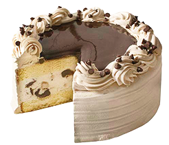 cookie dough chip cake: made with chocolate icing topped with chocolate shavings it is cut to show yellow cake sandwiching a layer of cookie dough chocolate chip ice cream