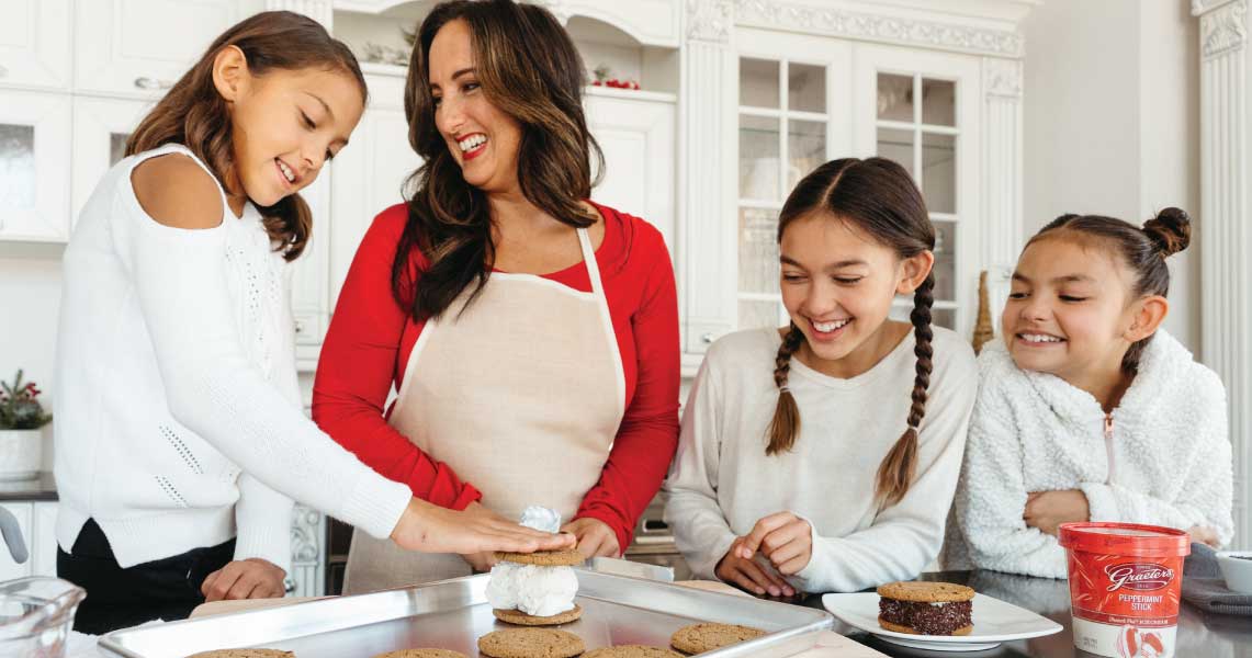 Mom making ice cream sandwiches with daughters